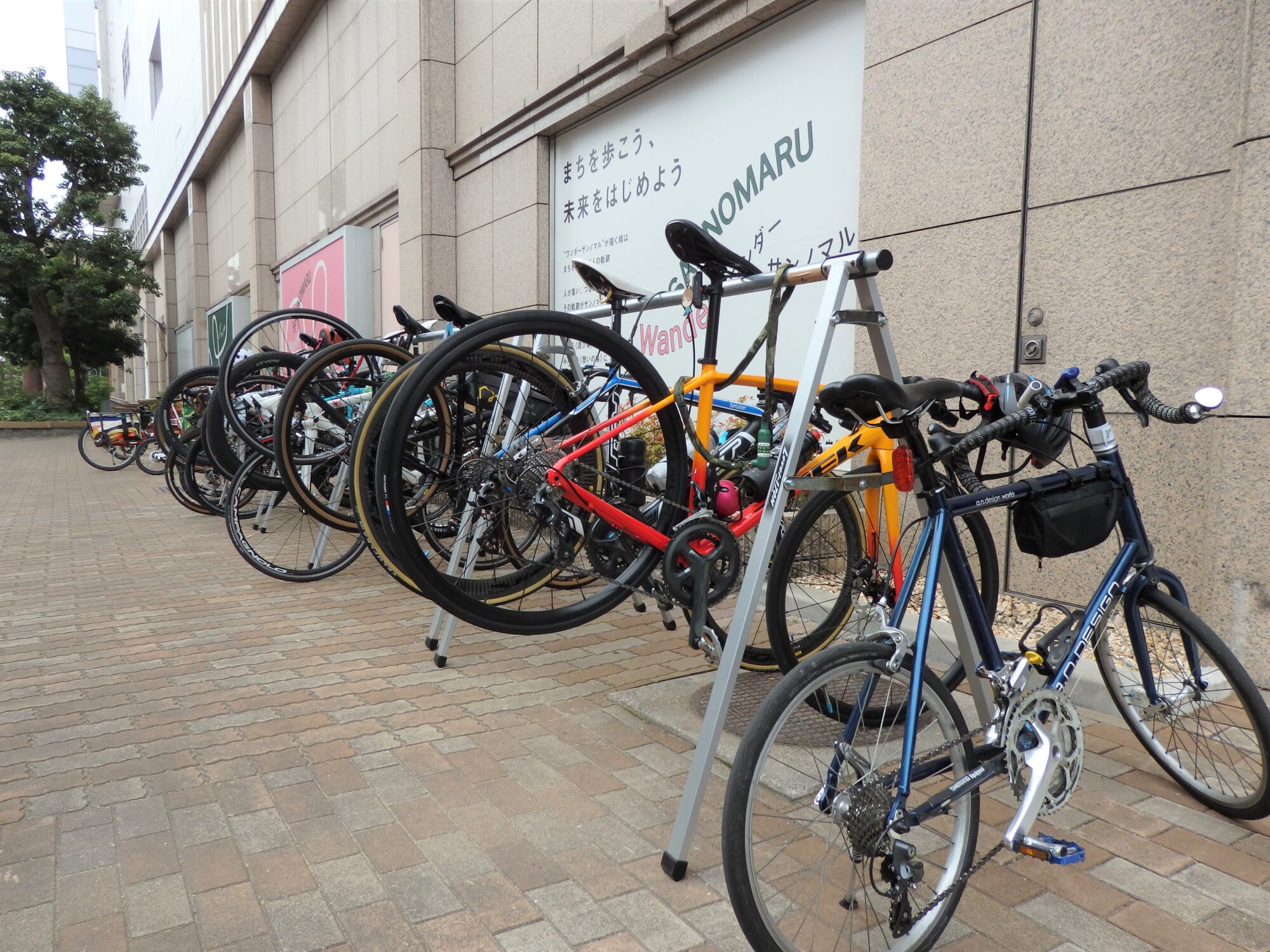 店頭に並ぶサイクリストの愛車が、図らずも優れた省スペース性をPRするの図