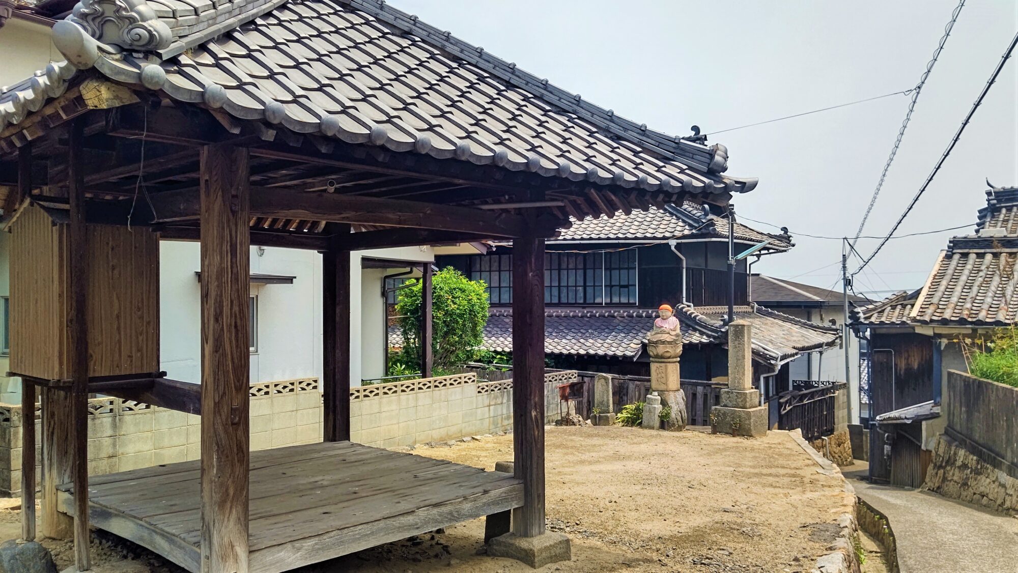 まち並みとマッチした小さなお堂。石仏に見守られ、地元のかたがたの憩いの場となっています。