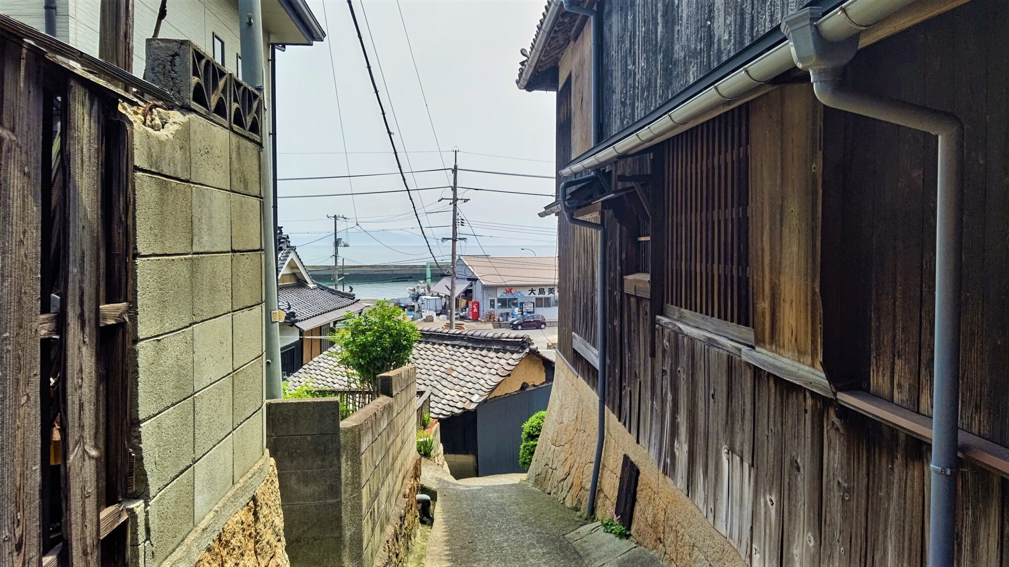 焼き板の民家の脇を、海へと下る狭い路地。