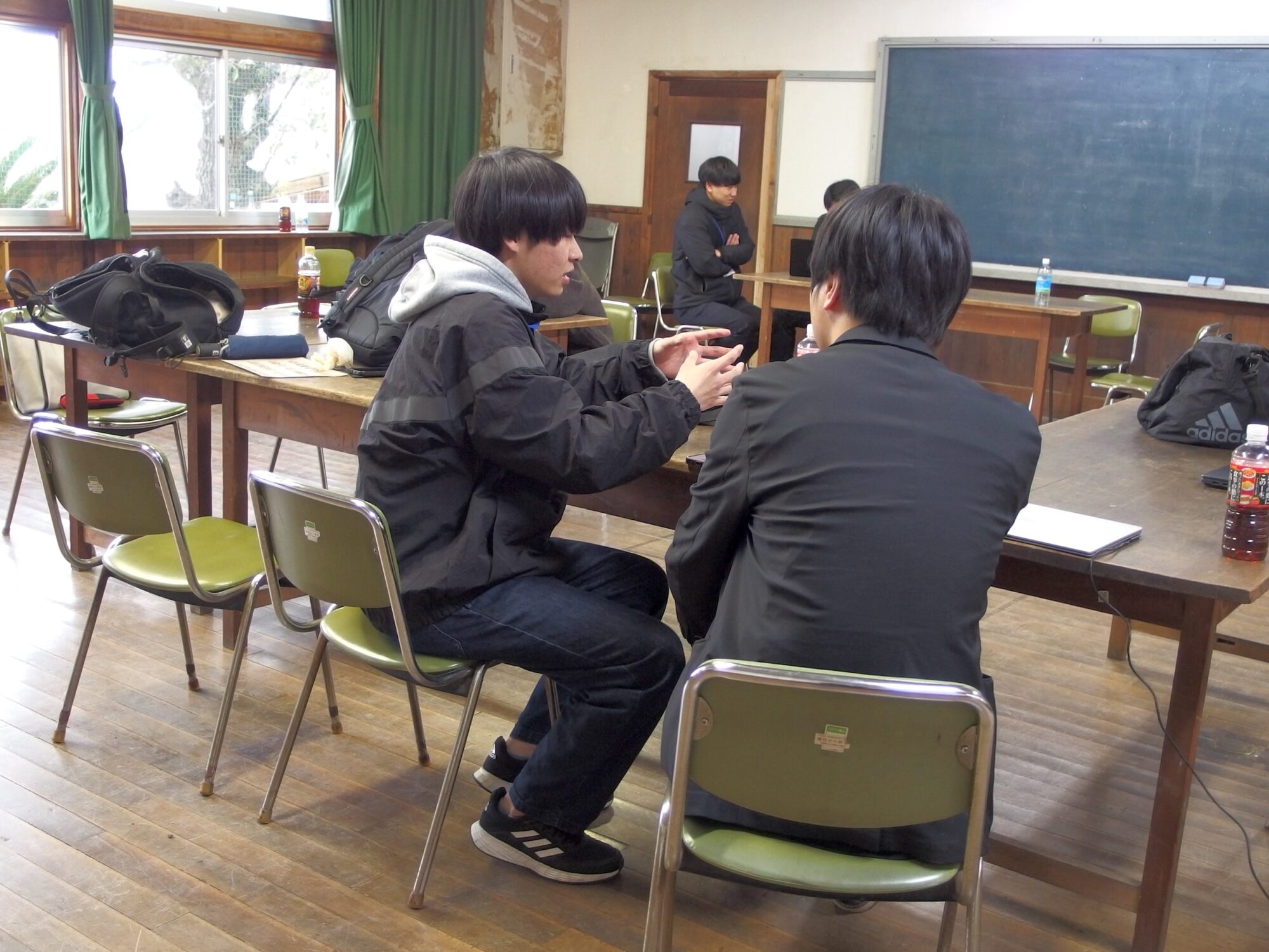 海の校舎でアドバイスを受ける学生たち