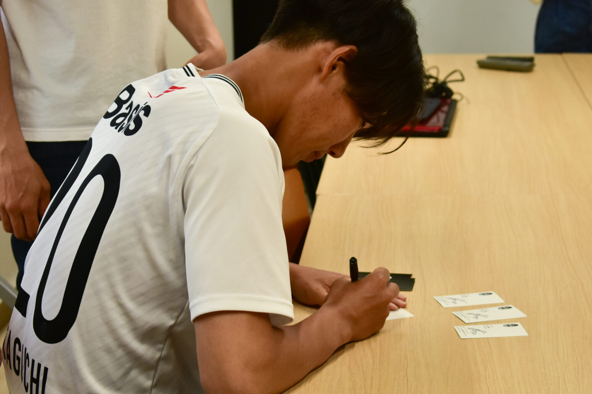 サインする田口駿さん