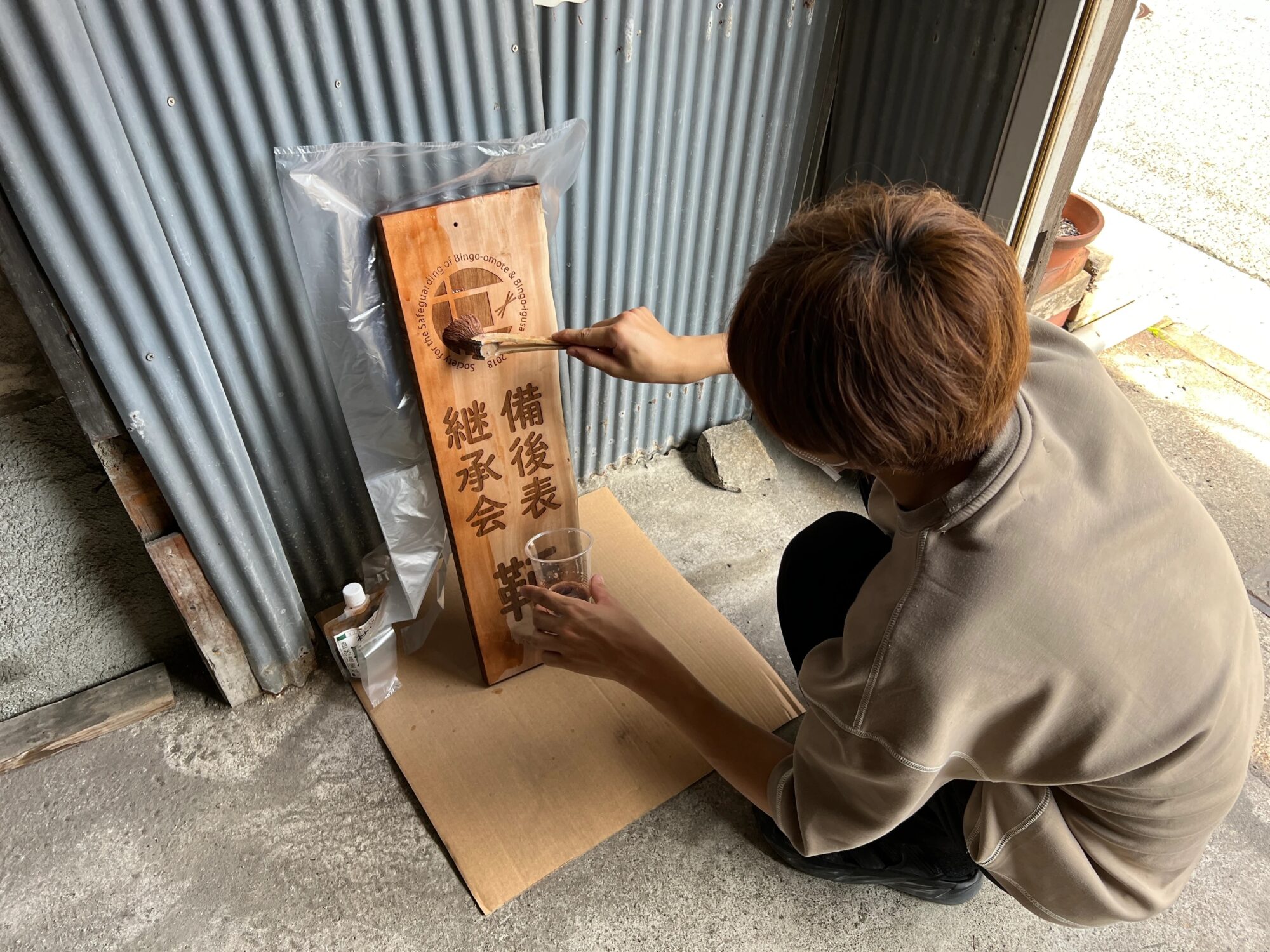 鞆事務所 開設時（昨年7月）の看板塗り　写真提供：備後表継承会