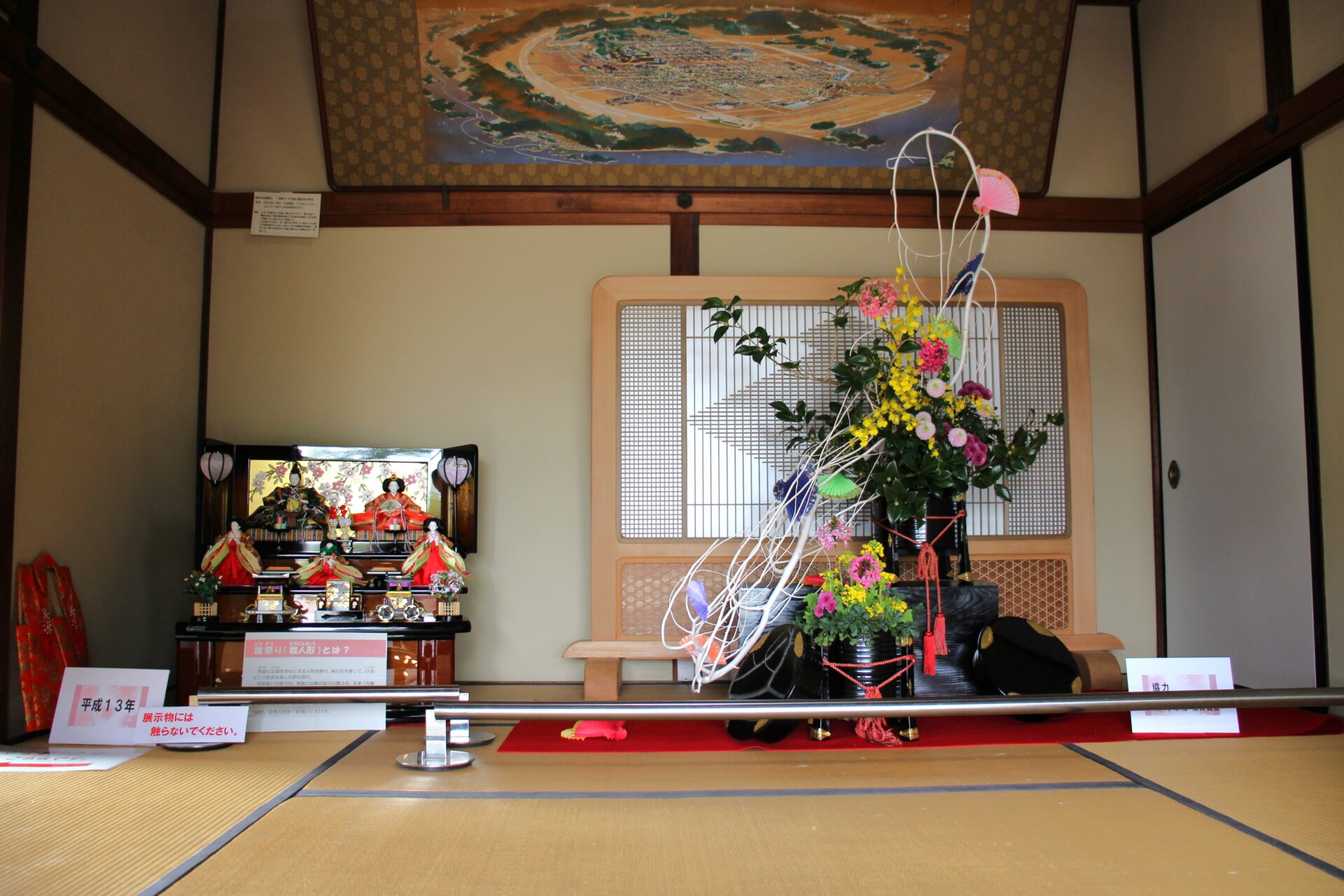 玄関に飾られた生け花とひな飾り