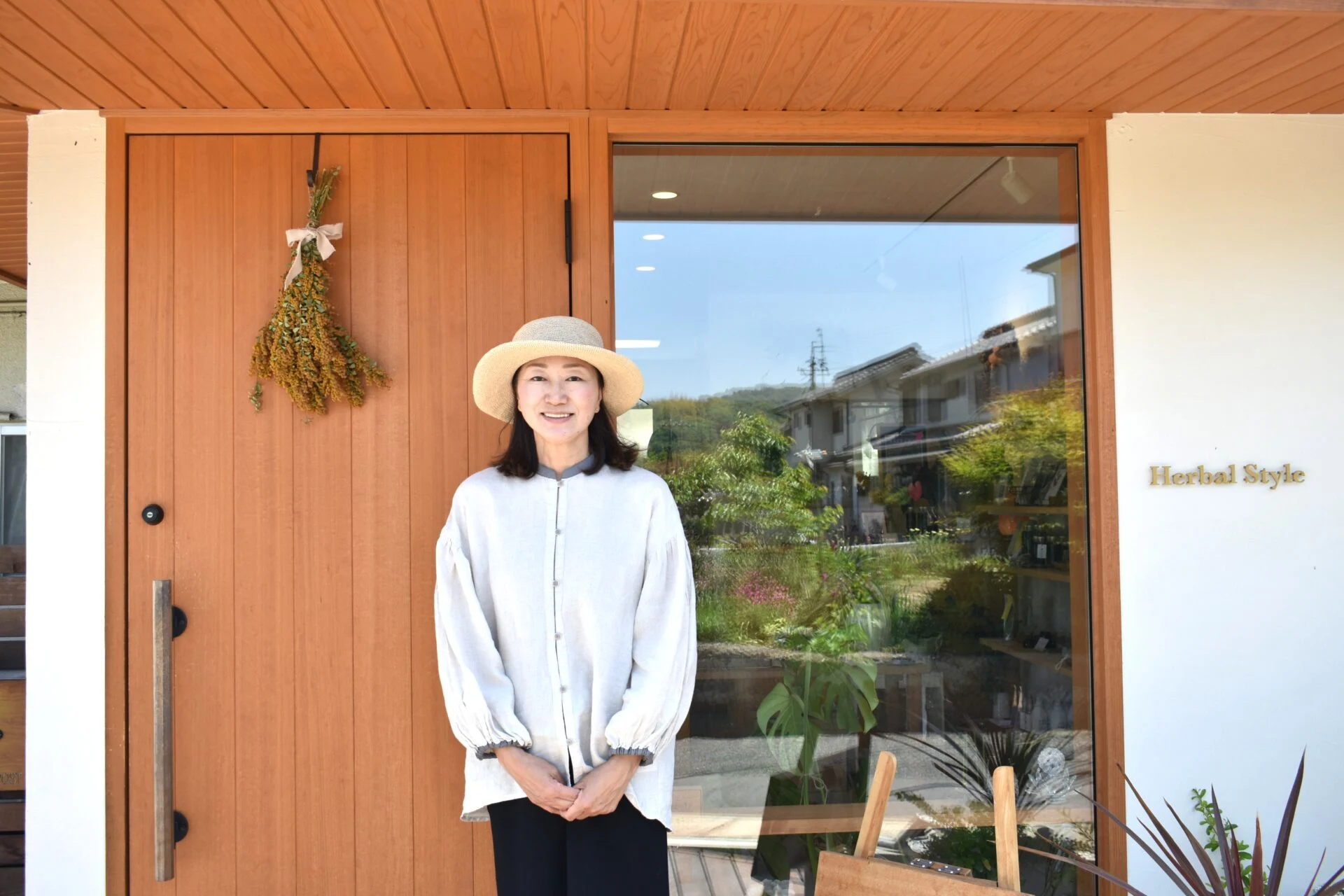 店舗を背に立つ宮澤さん