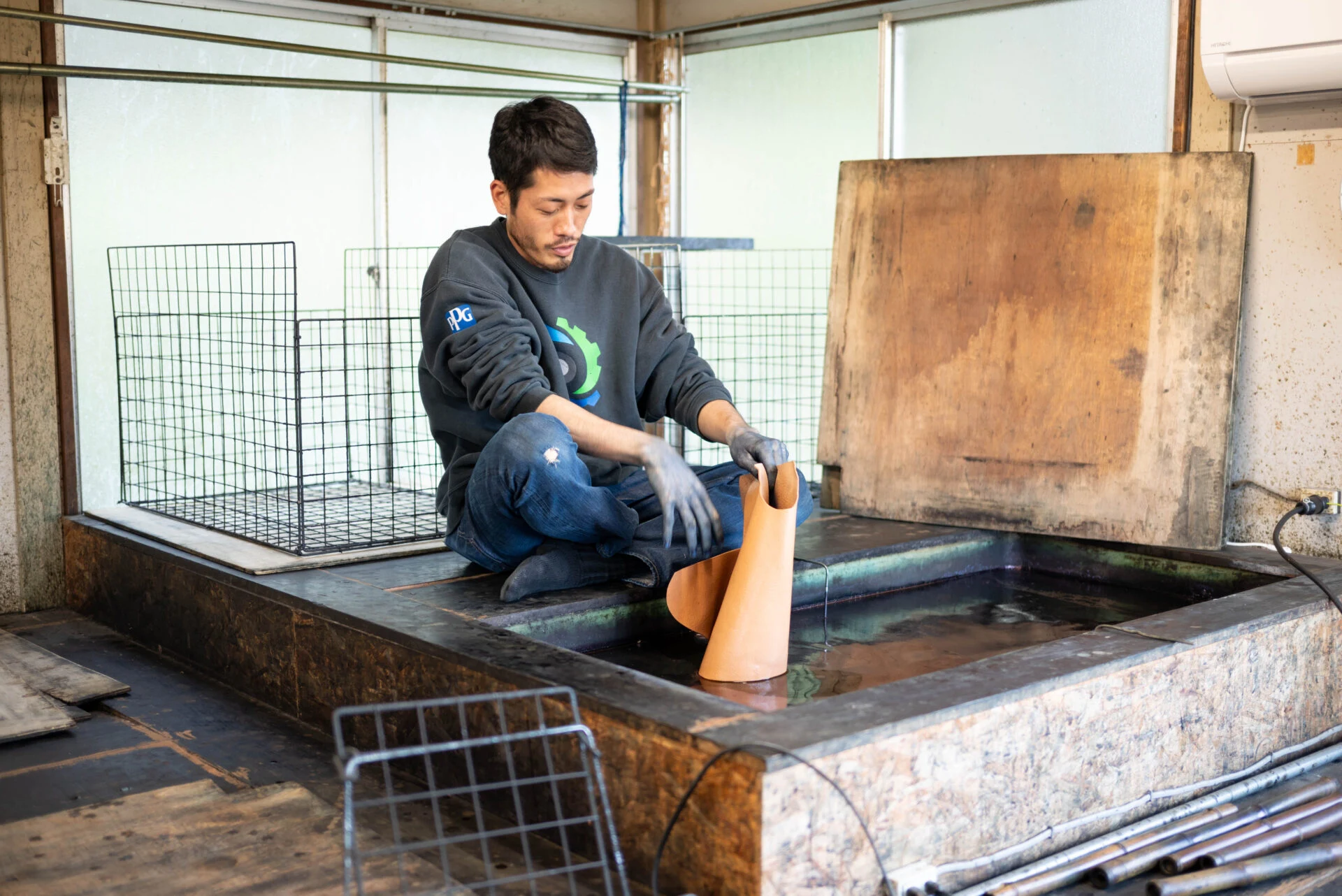 生成りの革を藍染液に浸す 微生物が働きやすい温度になるよう、寒い時期は液を20～25℃くらいに加温している