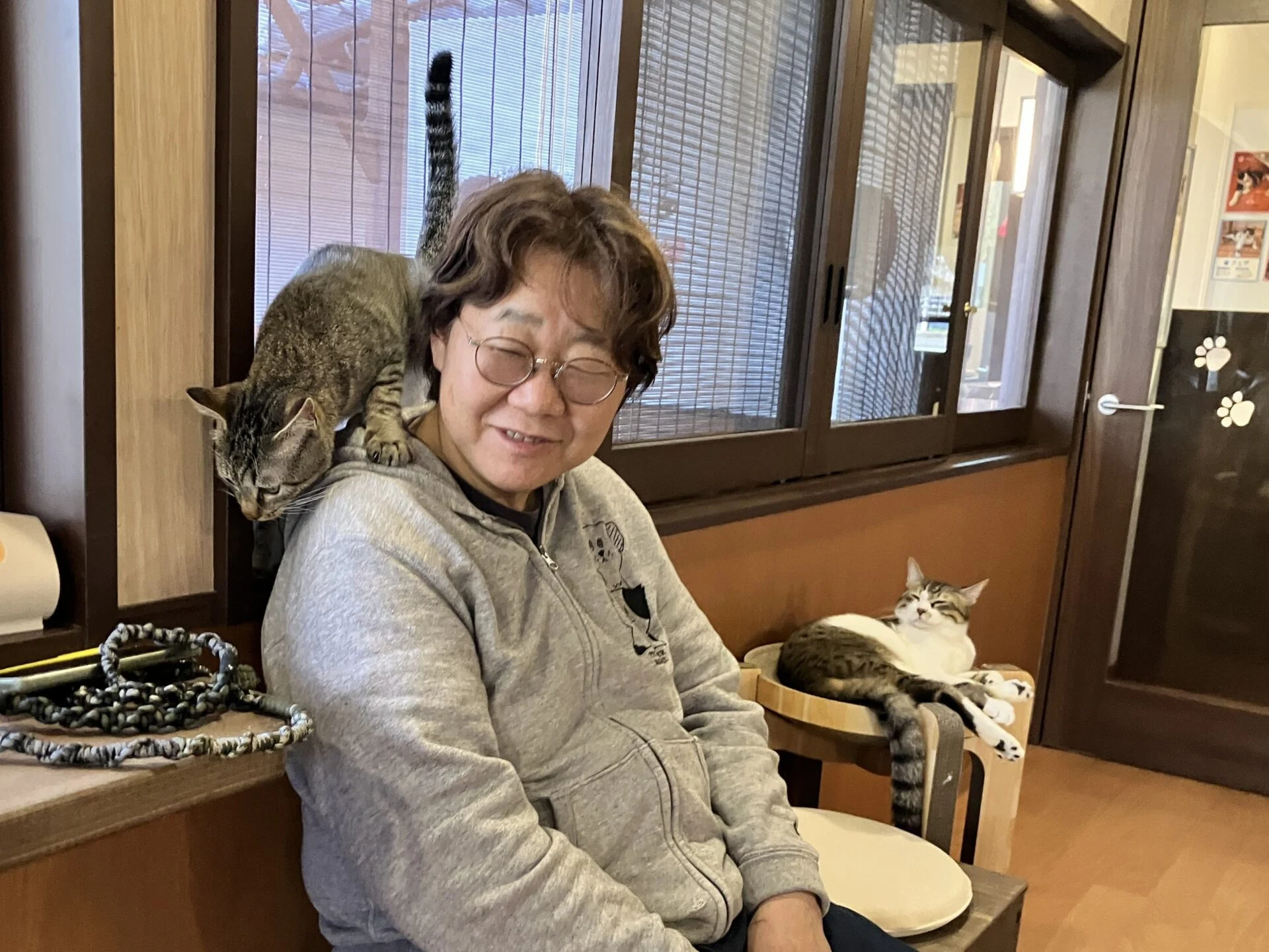 高橋さんの肩に乗るフク君と、傍らでくつろぐフェザ君